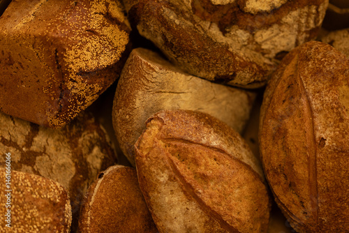 Obraz na płótnie Close-up of various artisan bread loaves, showcasing their crusty textures and golden-brown hues. Perfect for bakery websites or food blogs. w salonie