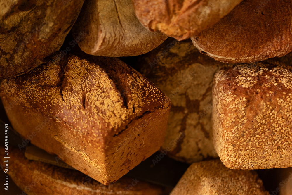 Close-up of various artisan sourdough bread loaves, showcasing textures and colors.
