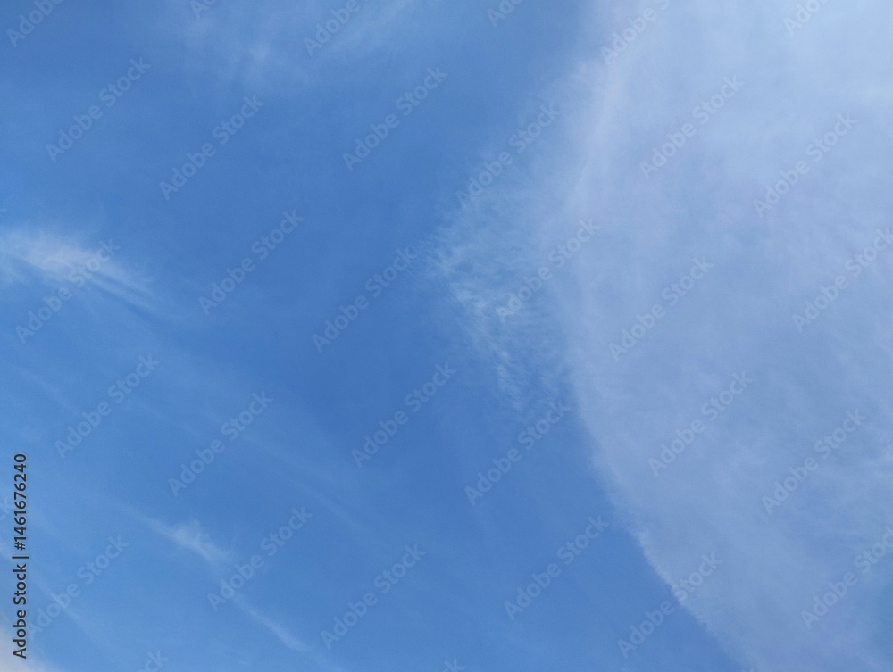 Fototapeta premium Bright blue sky with scattered thin clouds, natural background