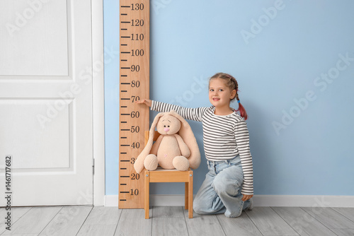 Little girl measuring toy's...