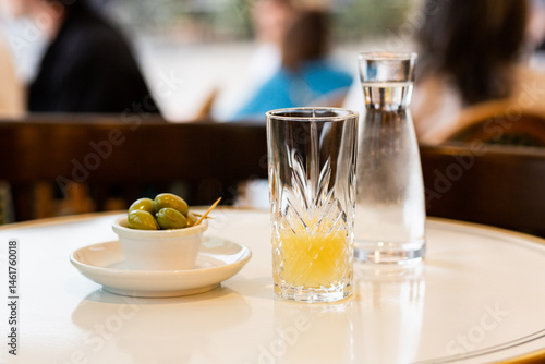 Un pastis et des olives vertes servis sur une table en terrasse, apéritif dans le sud de la France