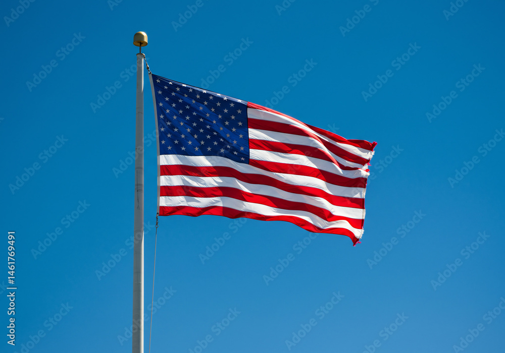 Fototapeta premium American Flag Waving in a Clear Blue Sky