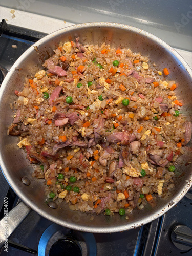 A pan of duck fried rice with vegetables.