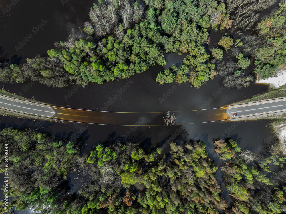 Lake District swallow hole flooded as a result of the mining damage Pomorzany mine in Olkusz,Poland. Aerial drone view of flooded road. Forest submerged in a lake. Sunken sandpit with clear water