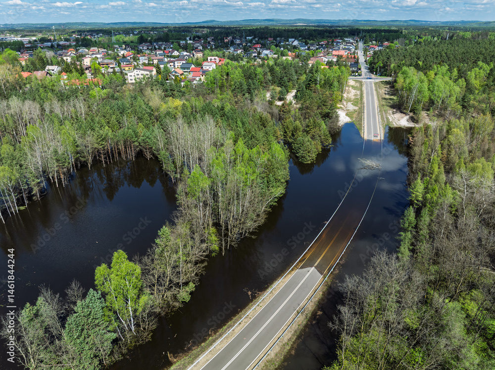 Lake District swallow hole flooded as a result of the mining damage Pomorzany mine in Olkusz,Poland. Aerial drone view of flooded road. Forest submerged in a lake. Sunken sandpit with clear water
