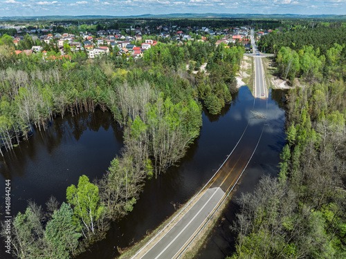 Obraz na płótnie Lake District swallow hole flooded as a result of the mining damage Pomorzany mine in Olkusz,Poland. Aerial drone view of flooded road. Forest submerged in a lake. Sunken sandpit with clear water w salonie