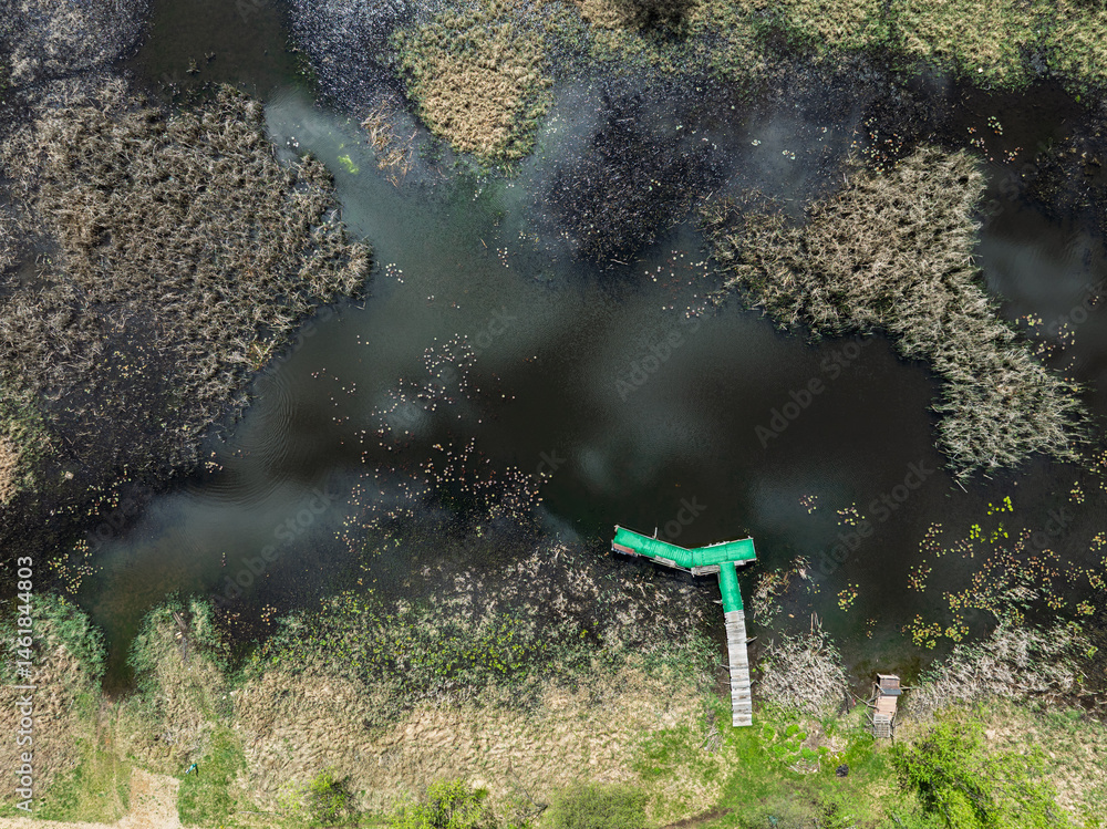 Lake District swallow hole flooded as a result of the mining damage Pomorzany mine in Olkusz,Poland. Aerial drone view of flooded road. Forest submerged in a lake. Sunken sandpit with clear water