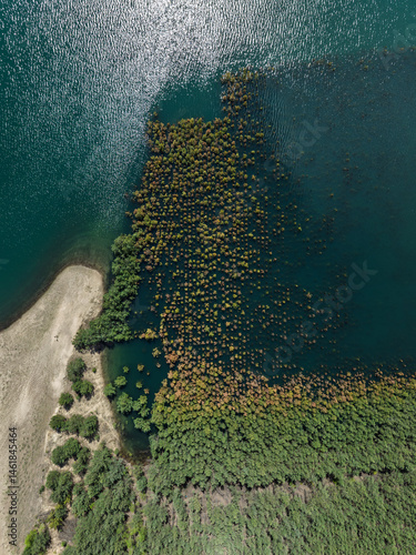 Obraz na płótnie Lake District swallow hole flooded as a result of the mining damage Pomorzany mine in Olkusz,Poland. Aerial drone view of flooded sand pit. Forest submerged in a lake. Sunken sandpit with clear water w salonie
