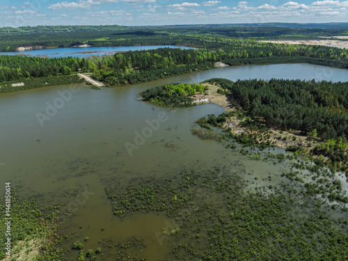 Obraz na płótnie Lake District swallow hole flooded as a result of the mining damage Pomorzany mine in Olkusz,Poland. Aerial drone view of flooded sand pit. Forest submerged in a lake. Sunken sandpit with clear water w salonie