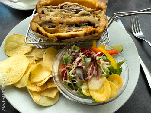 Obraz na płótnie Overhead view of lunch consisting of melted cheese sandwich, potato chips, and salad w salonie