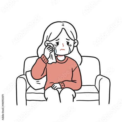 Woman sitting on a couch wiping tears with a tissue, expressing sadness and vulnerability, on a white background