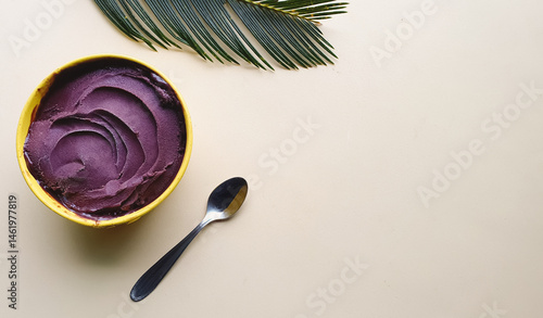
creamy chilled açaí with texture in a yellow bowl and light beige background with space for text