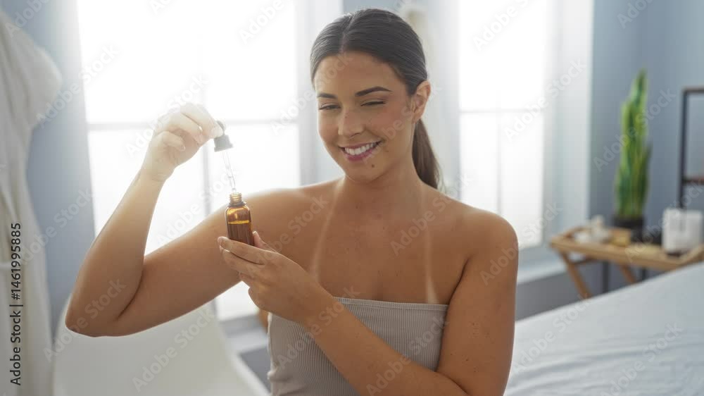 Brunette woman in spa wellness center holding aromatic oil in a relaxed indoor setting Brunette woman in spa wellness center holding aromatic oil in a relaxed indoor setting