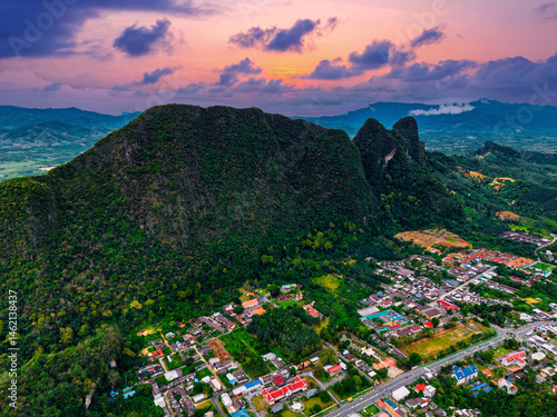 Aerial view of phang nga, thailand at sunset featuring lush mountains and vibrant townscape