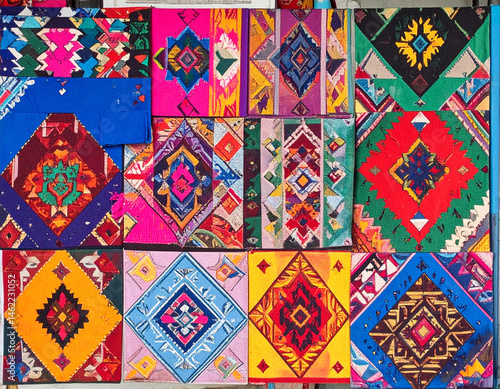 A colorful Ecuadorian textile pattern displayed at a vibrant rustic market.