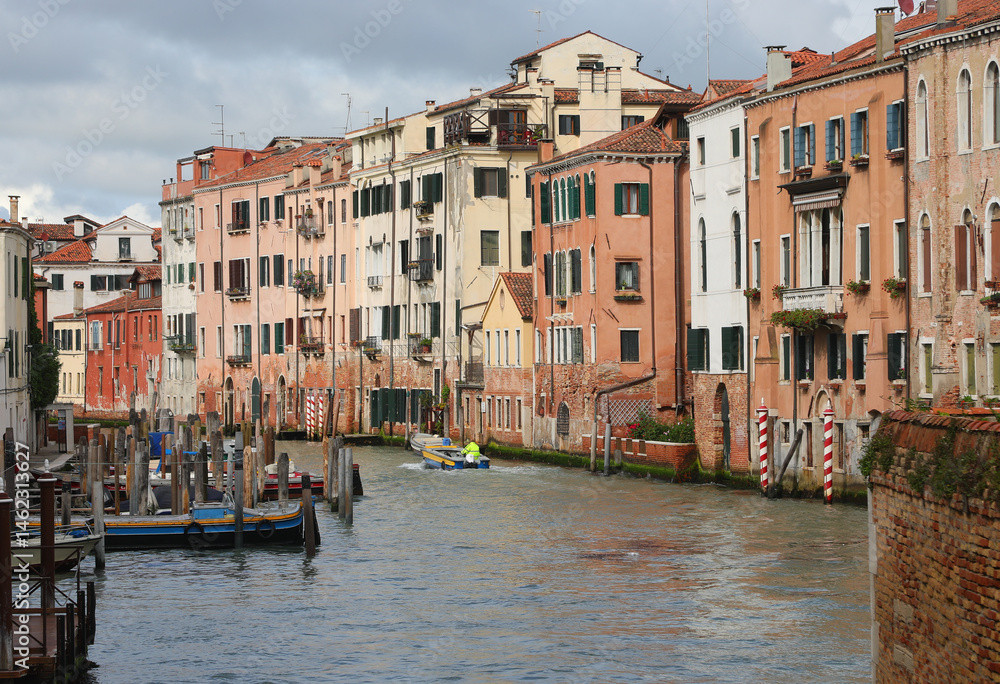 waterway with more moored boats and houses in Venice Island in Northern Italy
