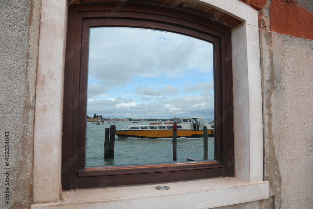 Boat mirrored in the glass of window in Venice Island in Northern Italy