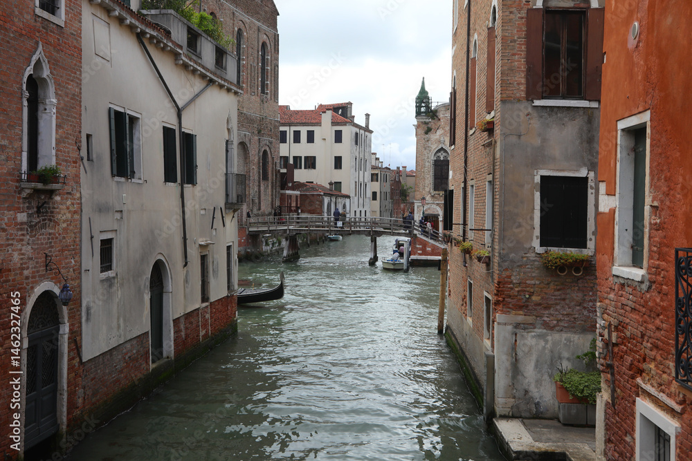 Houses and palace and the Bow of Gondola boat behind the corner on the navigagle waterway in Venice in Northern Italy