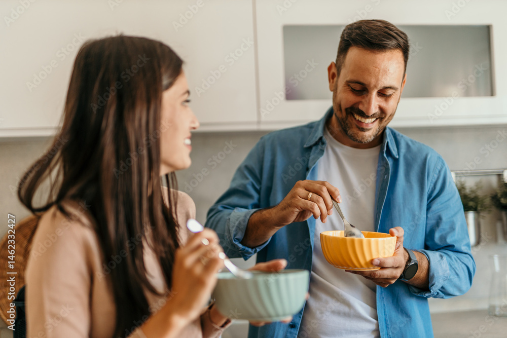 Happy couple enjoying breakfast together in modern kitchen Happy couple enjoying breakfast together in modern kitchen