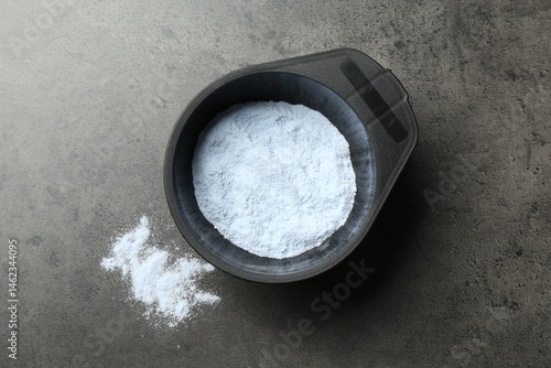 Foto Bowl with hair bleaching powder on grey table, top view