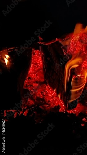 Vertical video of wood burning in a fireplace at night