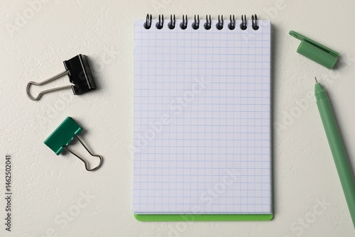 Notebook, pen and binder clips on white table, flat lay