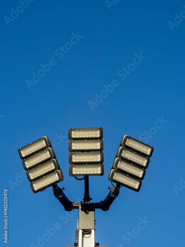 Obraz na płótnie Powerful mobile LED panels on a tall metal pole for sport event illumination or a concert. Blue cloudy sky background. Modern efficient technology. Floodlight ready for work. w salonie