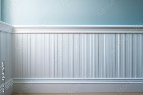 Elegant Interior Wall Corner Featuring White Wainscoting with Vertical Panels and Decorative Chair Rail Molding, Soft Light Blue Textured Upper Wall, Light Natural Wooden Flooring