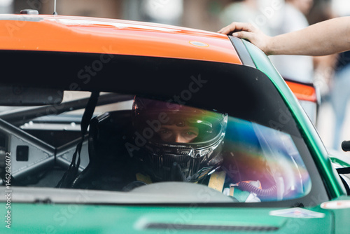 Racing Driver in Carbon Fiber Helmet Sitting Inside Race Car Cockpit During Track Day