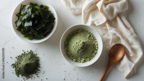Flat lay of seaweed powder in a white bowl and spoon, highlighting konbu and algae ingredients on a white background