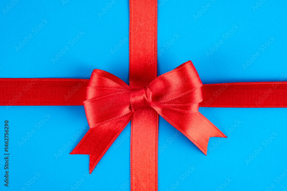 Red ribbon and bow on blue background