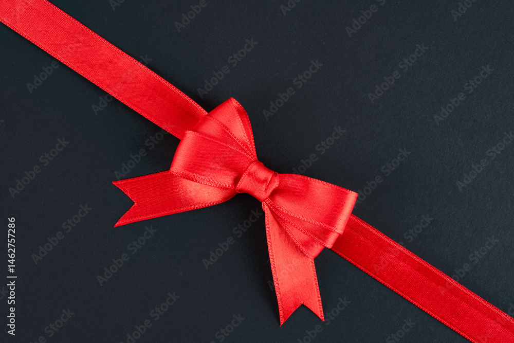 Red ribbon and bow on black background