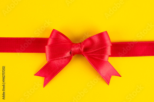 Obraz na płótnie Red ribbon and bow on yellow background w salonie