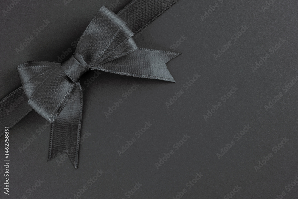 Black ribbon and bow on black background
