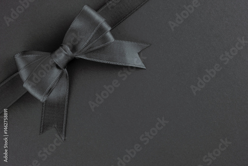 Obraz na płótnie Black ribbon and bow on black background w salonie