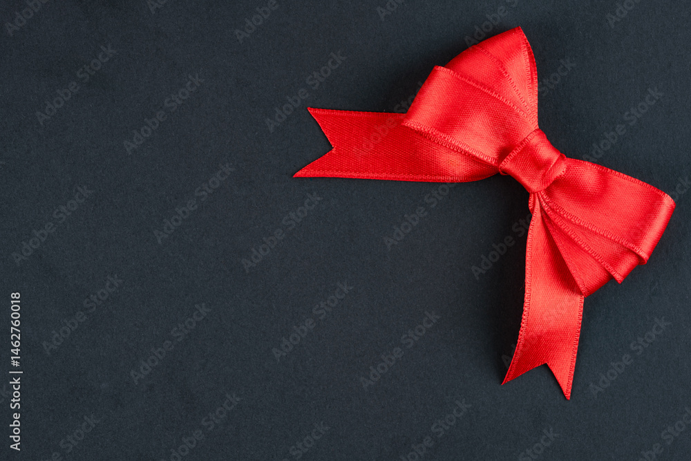Red ribbon and bow on black background
