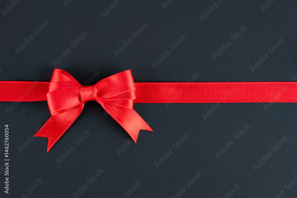 Red ribbon and bow on black background