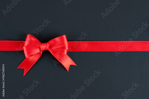 Obraz na płótnie Red ribbon and bow on black background w salonie