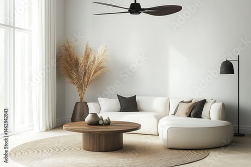 Modern minimalist living room featuring a light beige sectional sofa, a round wooden coffee table, and pampas grass.  A ceiling fan hangs above, and natural light floods the room