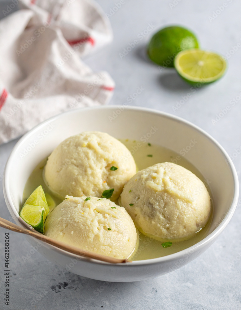 A steaming bowl of Maldivian gulha dumplings with a side of lime wedges. A steaming bowl of Maldivian gulha dumplings with a side of lime wedges.