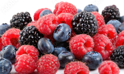 Obraz na płótnie A colorful mix of fresh raspberries and blueberries on a white surface, great for food styling and photography w salonie
