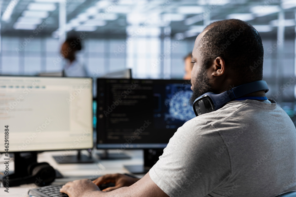 Computer scientist using artificial intelligence technology to optimize data center performance. African american IT expert in server farm using AI tech to accurately forecast potential issues