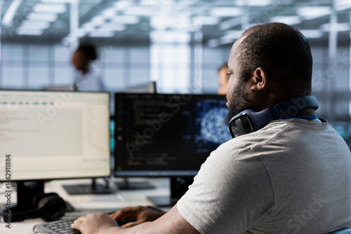 Obraz na płótnie Computer scientist using artificial intelligence technology to optimize data center performance. African american IT expert in server farm using AI tech to accurately forecast potential issues w salonie