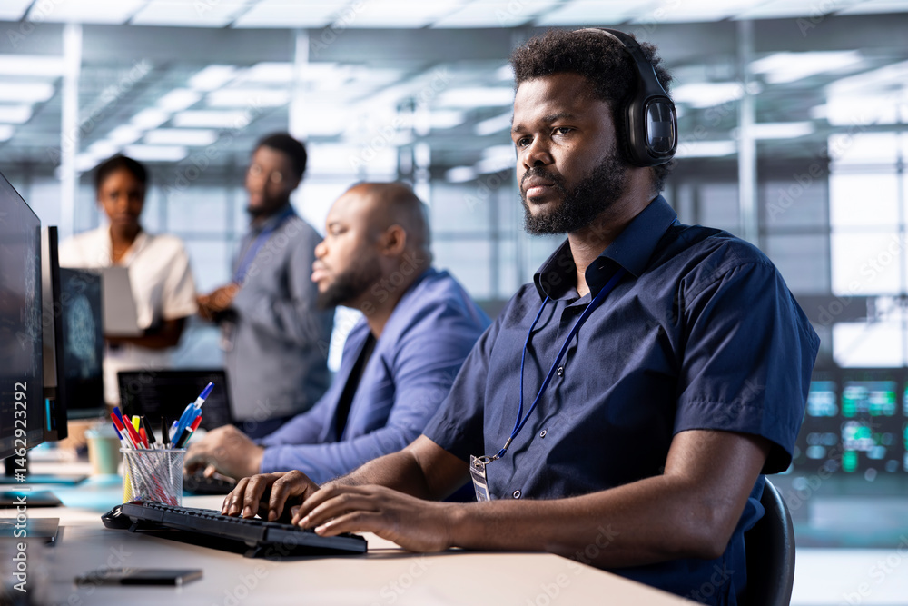 Cybersecurity expert wearing headphones, listening music while monitoring security incidents affecting server hub network. Developer hearing songs in data center and protecting company from threats