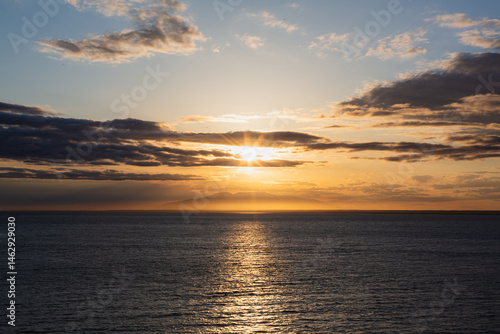 A vibrant sunset casts its colors over Cook Inlet in Anchorage, Alaska.