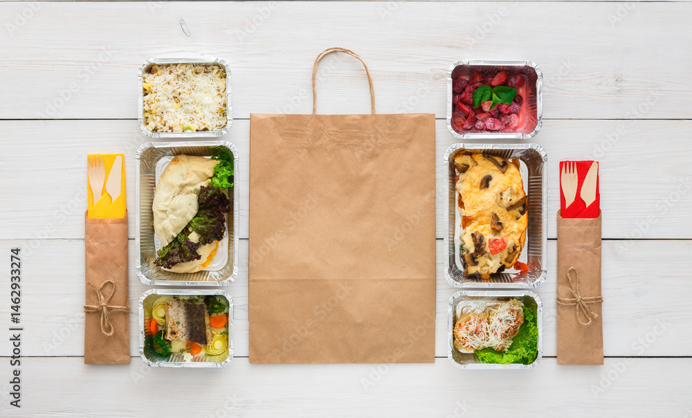Obraz premium Healthy food delivery. Take away of natural organic fitness dishes for diet. Daily ratio meals in foil boxes on white wood. Craft package, vegetables, meat and salads. Top view, flat lay