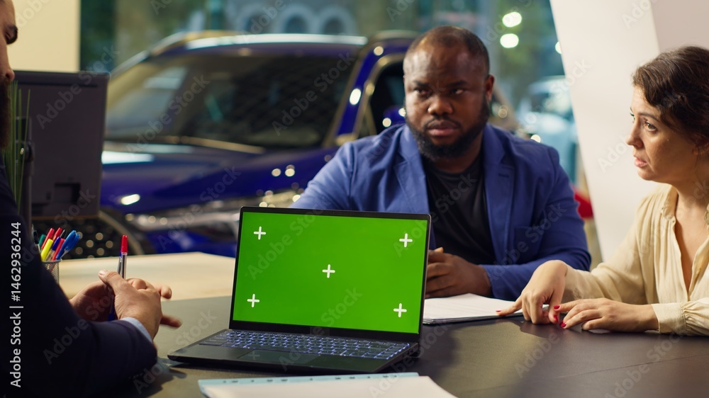 Dealership salesman looking over appointment list on chroma key laptop spreadsheet to schedule car test drive. Showroom agent arranging meeting with clients using isolated screen notebook, camera A