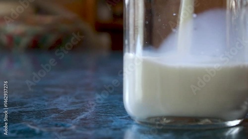 pouring delicious fresh milk in a tumbler