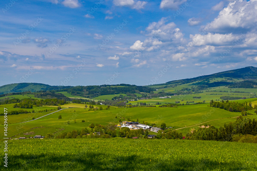 Breathtaking Czech landscape with green meadows, forested hills, and distant mountains on a sunny day. A perfect example of unspoiled nature and peaceful countryside. Breathtaking Czech landscape with green meadows, forested hills, and distant mountains on a sunny day. A perfect example of unspoiled nature and peaceful countryside.