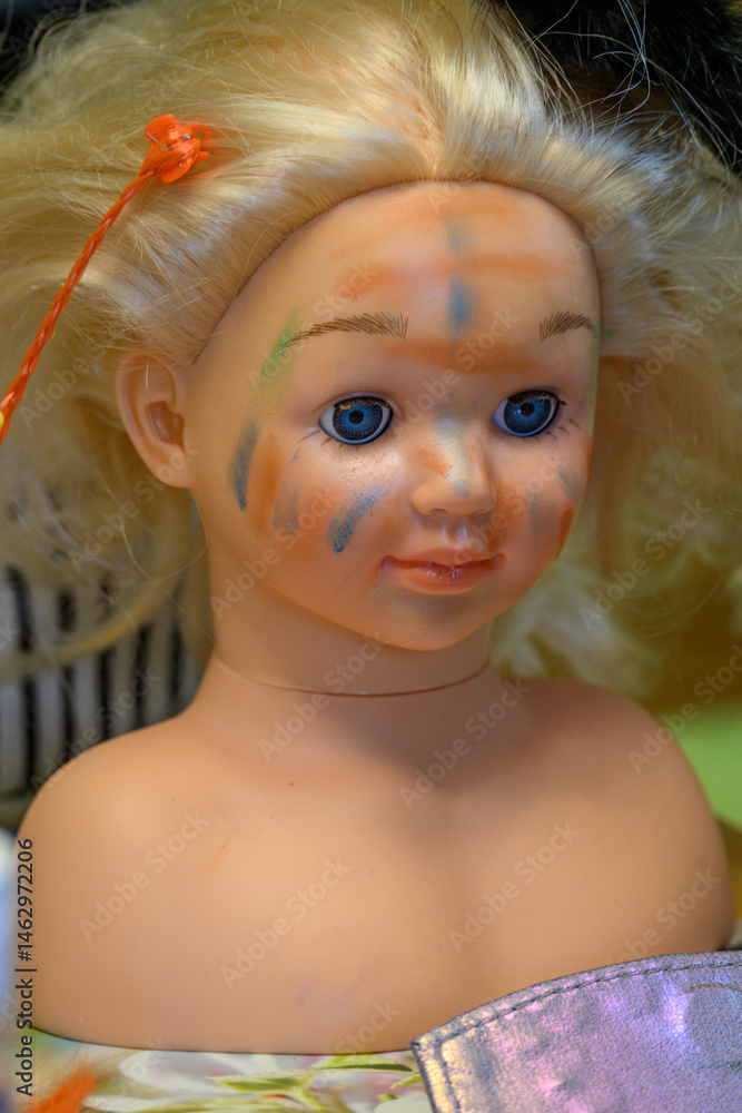 Plastic face painting bust with blonde hair.